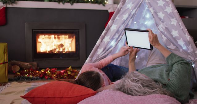 Grandparent and Child Enjoying Tablet Near Cozy Fireplace at Home - Download Free Stock Images Pikwizard.com