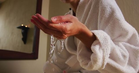 Woman checking bath water temperature in relaxed home setting