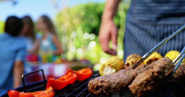 Man Grilling Meat Skewers During Relaxed Outdoor Barbecue - Download Free Stock Images Pikwizard.com