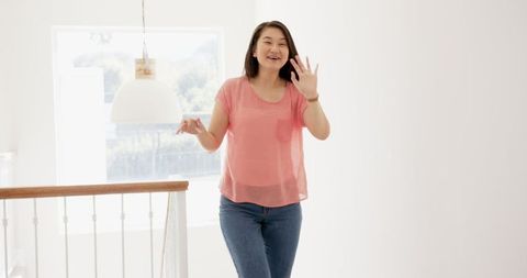 Friendly Asian Woman Greeting on Staircase Near Wooden Handrail