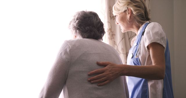 Nurse providing companionship to an elderly woman as they look outside. Suitable for illustrating concepts of caregiving, healthcare support for seniors, and the importance of human connection in medical care. Ideal for use in healthcare brochures, senior care advertisements, medical blog posts, or retirement community websites.