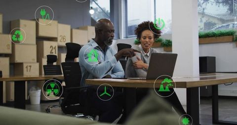 Collaborating on sustainable business planning with laptop and green renewable energy icons