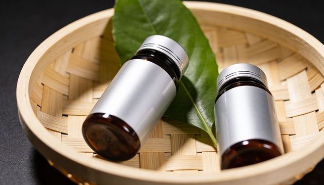 Amber glass serum bottles with silver caps on bamboo tray for skincare branding