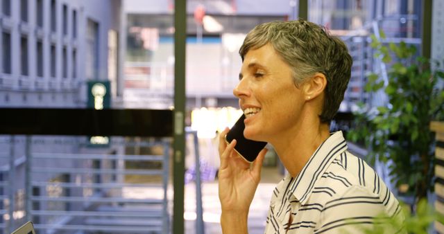 Businesswoman Smiling While Talking on Mobile Phone in Office - Download Free Stock Images Pikwizard.com