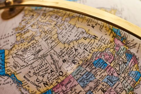 Antique globe showing north america with gold metal arm