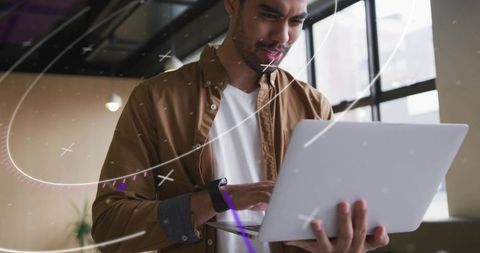 Focused Developer Working on Laptop in Modern Office