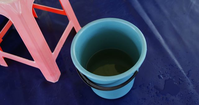 Empty Blue Plastic Bucket on Floor beside Pink Plastic Stool - Download Free Stock Images Pikwizard.com