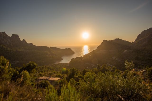 Capturing the serene beauty of a golden sunset over the Mediterranean coastline with rugged mountains and shimmering ocean. Ideal for travel brochures, relaxation retreats, outdoor adventure advertisements, or nature-themed publications.