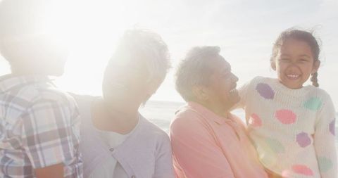 Joyful Hispanic Family Bonding on Beach During Golden Hour