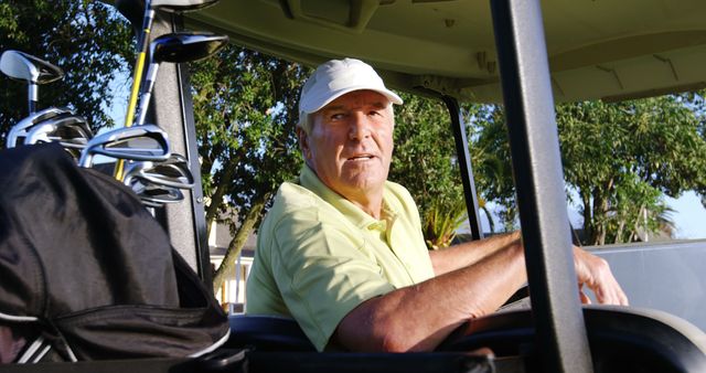 Golfer sitting in golf buggy at golf course