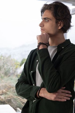 Man pondering near window with scenic view