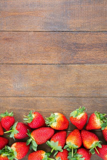 Fresh strawberries arranged on wooden board