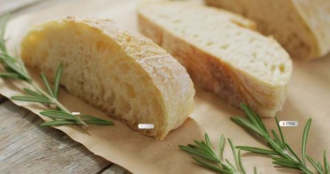 Rustic ciabatta slices resting on parchment with fresh rosemary and golden crust