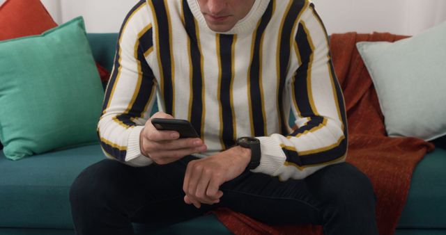 Man With Striped Sweater Using Smartphone on Cozy Sofa - Download Free Stock Images Pikwizard.com