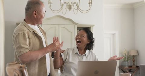 Senior Asian Couple Joyfully Video Chatting at Home