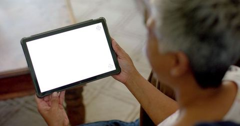 Senior woman using tablet with blank screen at home