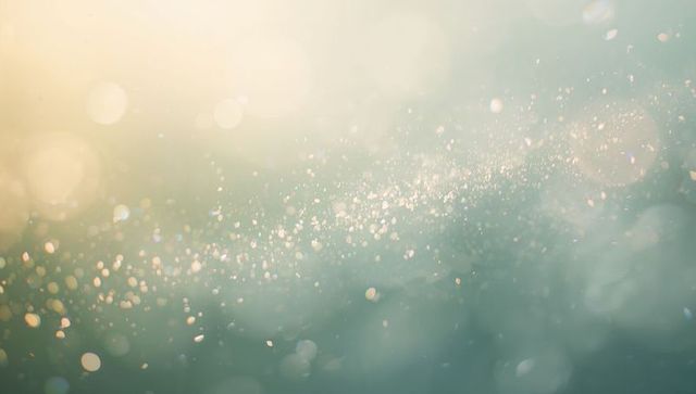 Dreamy teal gold bokeh shimmer background floating light particles and ethereal soft glow