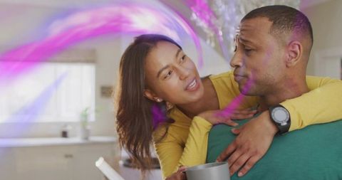 Couple sharing cozy morning hug in bright kitchen, woman leaning on partner's shoulder