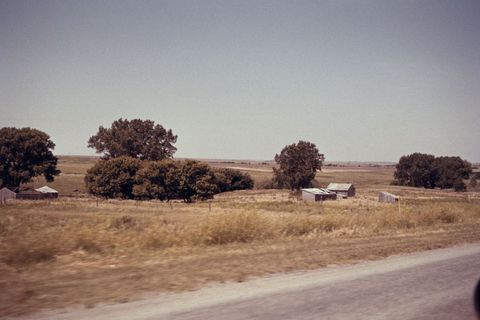 Rural Landscape with Fields and Old Barns Under Clear Blue Sky