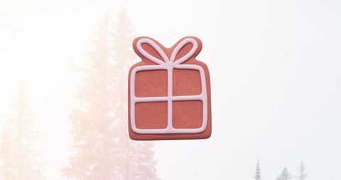 iconic gingerbread cookie shaped like a gift, capturing festive cheer. background with subtle winter wonderland elements featuring snow. perfect for digital holiday marketing, christmas-themed greeting cards, online festive decoration ideas, or traditional baking inspiration content.