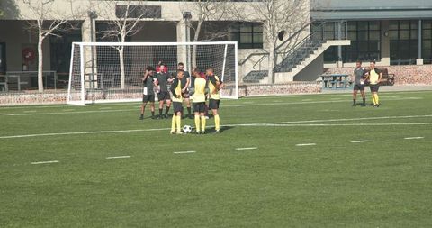 Soccer Players in Yellow Uniforms Gather on Field for Match