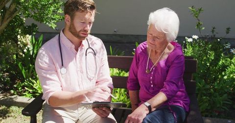 Doctor Discussing Health Results with Senior Woman Outdoors