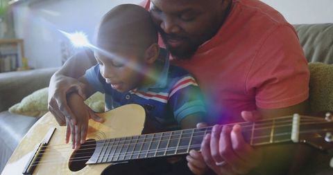 Father Teaching Son to Play Guitar at Home With Joy and Warmth
