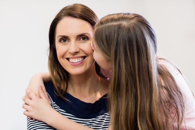 Mother and daughter sharing a tender moment in a home environment. Perfect for use in family-oriented advertisements, parenting blogs, and articles about family relationships and love.