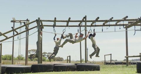 Energetic soldiers training on outdoor obstacle course in sunshine