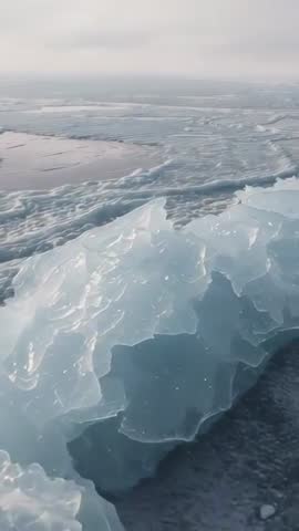 Panning Vertical Video Revealing Translucent Glacial Ice Block on Sea Ice with Melt Pools