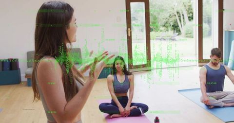 Female yoga coach leading small group with green data overlay in bright home studio