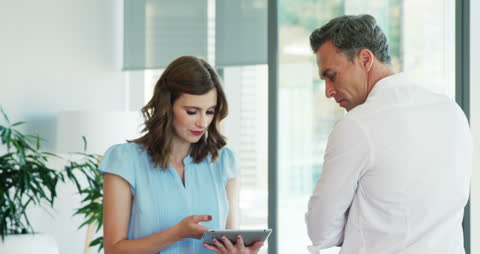 Business Colleagues Discussing on Tablet in Modern Office