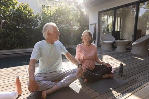 Senior Couple Practicing Yoga Outdoors with Fitness Trackers