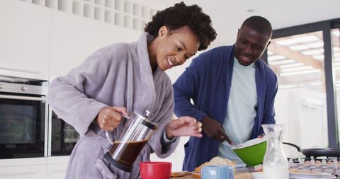 Joyful Couple Enjoying Breakfast Preparation in Modern Kitchen