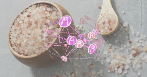 Glowing holographic network hovering over bowl of himalayan pink salt on gray countertop