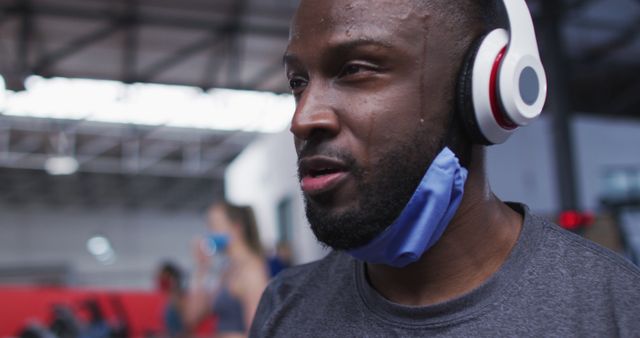 Man Working Out in Gym with Headphones and Face Mask - Download Free Stock Images Pikwizard.com