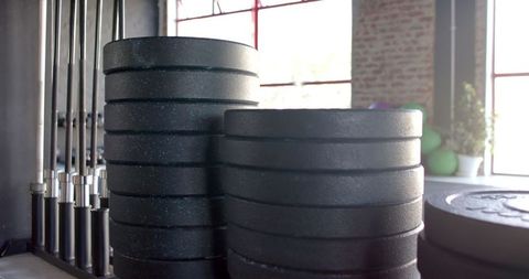 Stacked Black Weight Plates in Sunlit Gym Setting - Download Free Stock Images Pikwizard.com