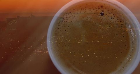 Coffee cup reflecting city skyline at dusk with rich crema and bokeh lights