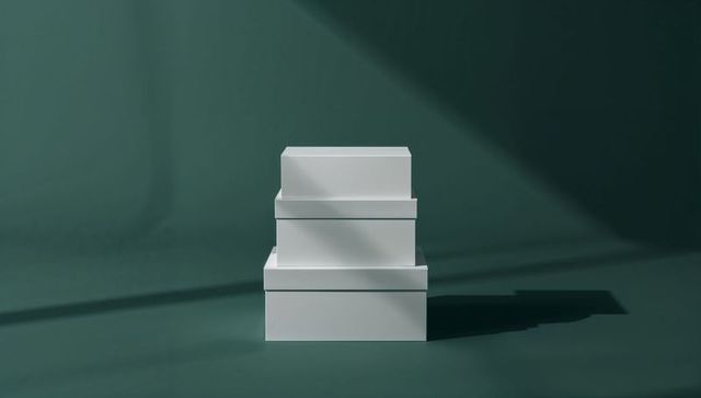 Minimalist Stack of White Boxes with Shadows on Dark Green Surface