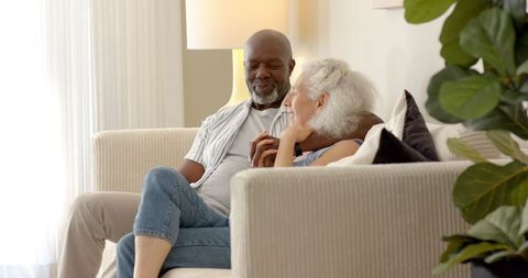 Senior couple relaxing at home in cozy living room interior