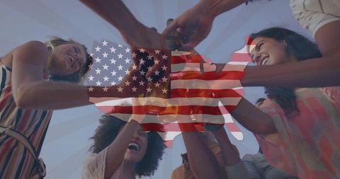 Friends toasting under united states flag silhouette during outdoor summer celebration