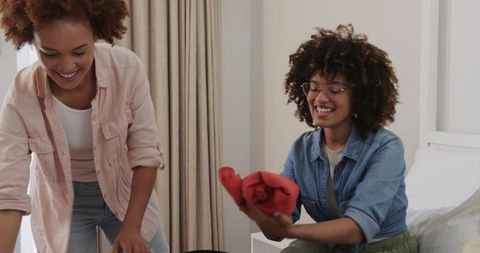 African American Friends Packing Weekend Luggage Together in Bright Cozy Bedroom