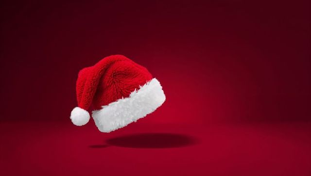 Floating Santa Hat on Red Background with White Fur Trim and Soft Shadow
