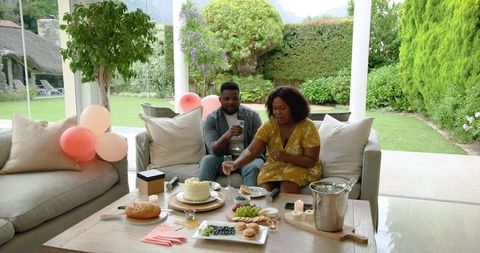 African American Couple Celebrating with Cake and Champagne on Patio