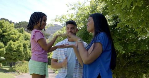 Family enjoying hand clapping game in scenic park