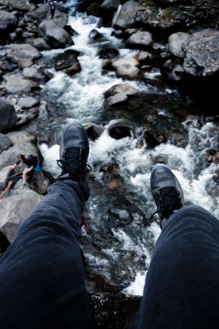 Person Sitting with Feet Dangling Over Fast-Flowing Stream - Download Free Stock Images Pikwizard.com