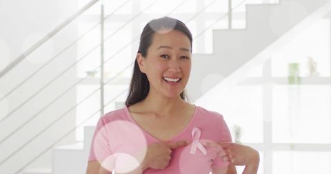 Happy Woman Supporting Breast Cancer Awareness with Pink Ribbon