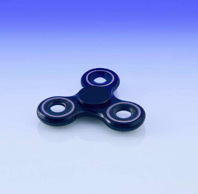 Image of black and purple fidget spinner on purple background. Playing object and toy concept.
