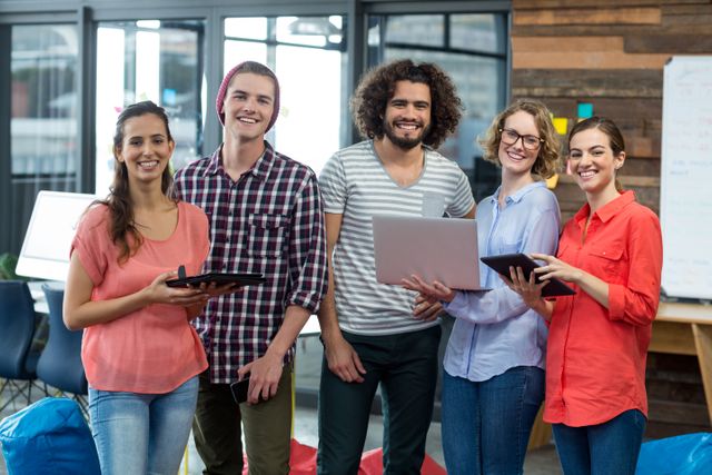 Smiling Young Professionals with Digital Devices in Modern Office - Download Free Stock Images Pikwizard.com