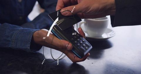 Contactless Card Tap at Cafe Table Using Mobile POS Terminal, Coffee Cup Nearby, NFC